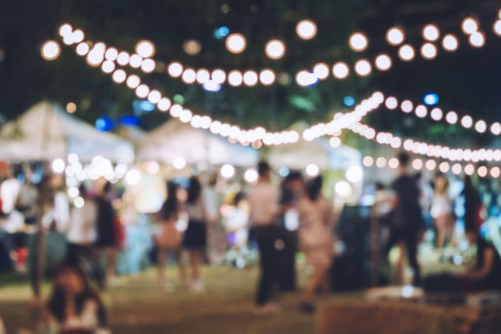 Apartments in Farragut Blurry image of an outdoor evening market with string lights overhead and indistinct figures of people moving about, capturing a vibe similar to rustic home decor.