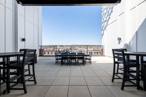 Apartments in for rent Farragut TN Rooftop patio with black tables and chairs overlooking a cityscape under a clear blue sky. Anchor 934 Apartments in Biddle Farms Town Center