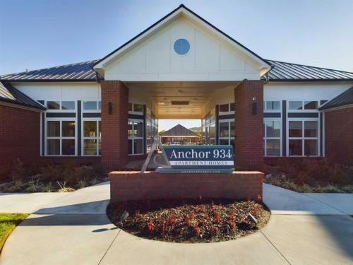 Apartments in for rent Farragut TN Front view of Anchor 934 Apartment Homes entrance with a landscaped pathway and a sign displaying the name. Anchor 934 Apartments in Biddle Farms Town Center