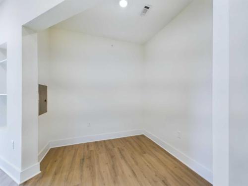 Apartments in for rent Farragut TN Small empty room with white walls and wood flooring, featuring a recessed area and a small square panel on the left wall. Anchor 934 Apartments in Biddle Farms Town Center